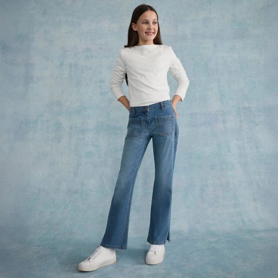 Biała bluzka w zestawieniu z jeansami skinny fit i białymi butami.