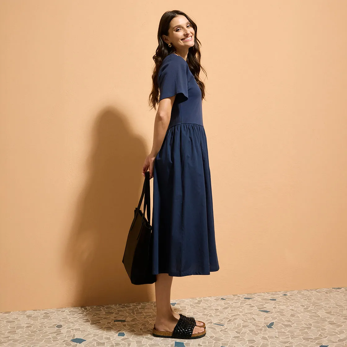 Elegancka, ciemnoniebieska sukienka na lato z krótkimi rękawami tworzy klasyczny, ponadczasowy look.
