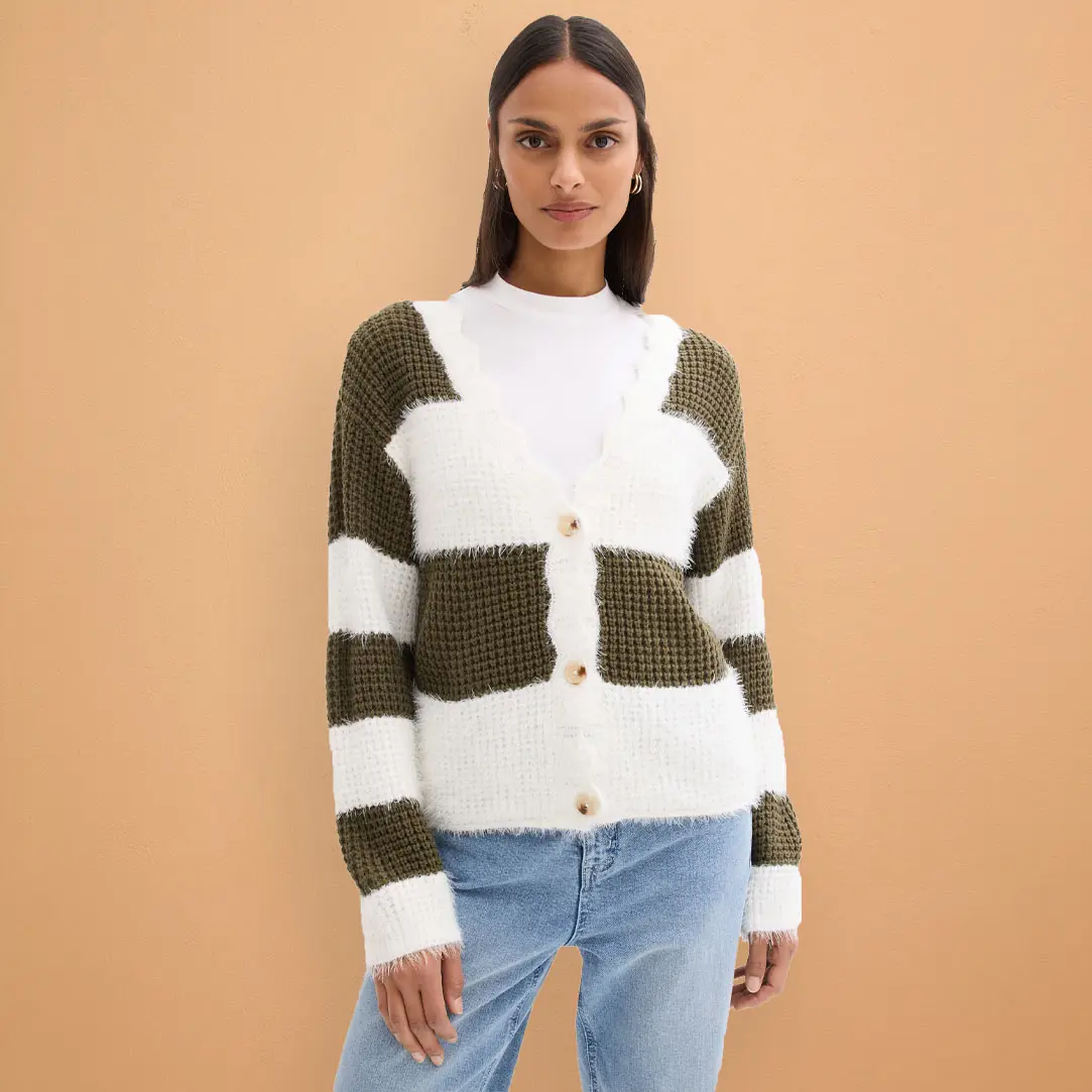 Dzianinowy kardigan w odcieniach bieli i oliwki, zestawiony z jasnoniebieskimi jeansami, tworzy harmonijną, codzienną stylizację.