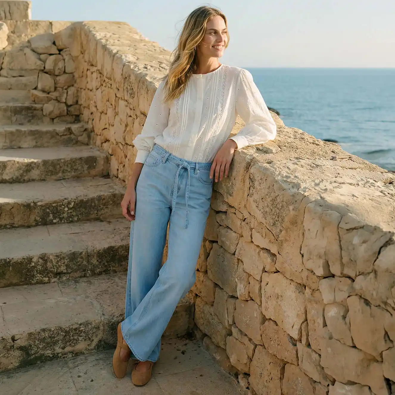 Przewiewna biała bluzka, do tego jasnoniebieskie jeansy.